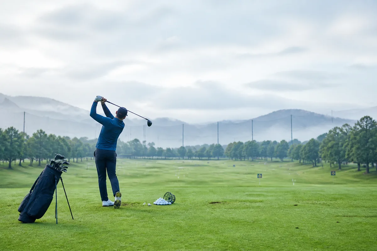 Golfer on the practice range at dawn
